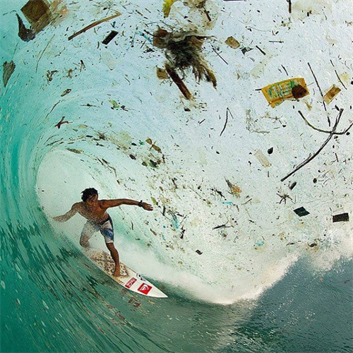 Surfer in a wave of trash